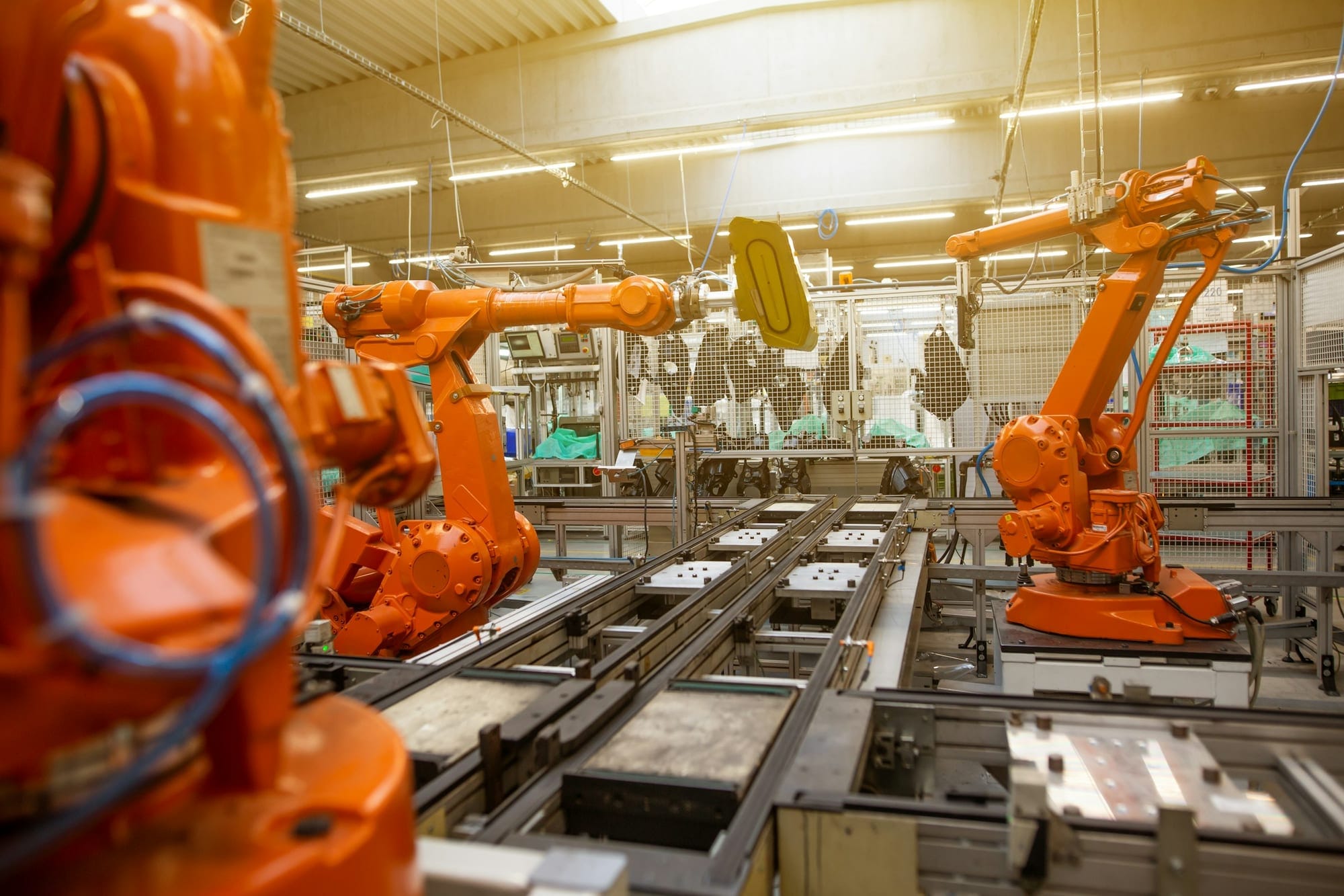 Otomotiv üretim hattında turuncu endüstriyel robotlar